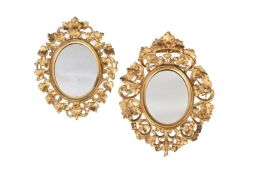 TWO SIMILAR CONTINENTAL CARVED GILT WOOD FRAMED OVAL MIRRORS