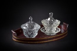 TWO FACET-CUT OGEE GLASS BOWLS AND COVERS AND A STAND AND AN ASSOCIATED STAINED WOOD TRAY