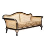 AN EBONISED, PARCEL GILT AND CANED SOFA