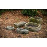 A GROUP OF FIVE VARIOUS CARVED STONE TROUGHS OR BASINS