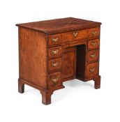 A GEORGE II WALNUT AND FEATHER-BANDED KNEEHOLE DESK, CIRCA 1735