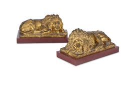 A PAIR OF GILT METAL FIGURES OF RECUMBENT LIONS, 19TH CENTURY