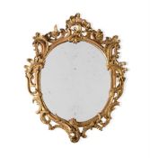 A CARVED GILTWOOD OVAL MIRROR, IN GEORGE III STYLE, SECOND QUARTER 19TH CENTURY