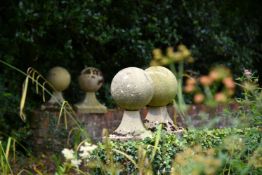A SET OF FOUR COMPOSITION STONE SPHERE FINIALS ON BASES, 20TH CENTURY