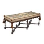 AN EBONISED AND NEEDLEWORK UPHOLSTERED RECTANGULAR LONG STOOL