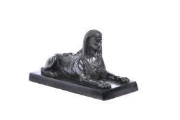 A PATINATED BRONZE MODEL OF AN EGYPTIAN SPHINX