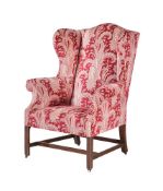 A GEORGE III MAHOGANY AND UPHOLSTERED WING ARMCHAIR