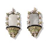 A PAIR OF CONTINENTAL PORCELAIN MOUNTED AND MIRRORED WALL BRACKETS