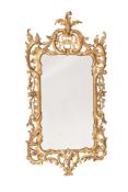 A CARVED GILTWOOD MIRROR IN GEORGE III STYLE