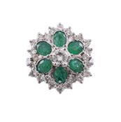 AN EMERALD AND DIAMOND FLOWER HEAD CLUSTER RING