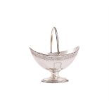 A GEORGE III SILVER NAVETTE SWING HANDLED PEDESTAL BASKET