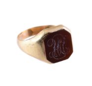 A CORNELIAN AND GOLD COLOURED SIGNET RING