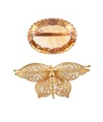 A VICTORIAN OVAL CUT CITRINE BROOCH AND A GOLD COLOURED FILIGREE BUTTERFLY BROOCH