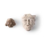 TWO FRAGMENTARY CARVED STONE HEADS, PROBABLY 11TH-13TH CENTURIES