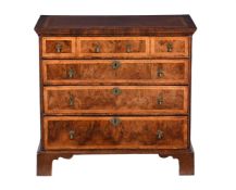 A WALNUT AND FEATHERBANDED CHEST OF DRAWERS