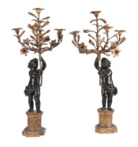 A PAIR OF EBONISED AND GILT FIGURAL CANDELABRA