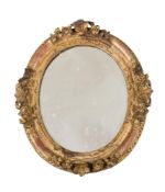 A VICTORIAN GILTWOOD AND COMPOSITION OVAL WALL MIRROR