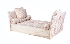A SLEIGH BED WITH EMBROIDERED LOOSE COVERS AND BOLSTER CUSHIONS