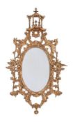 A GILTWOOD OVAL MIRROR IN GEORGE III STYLE