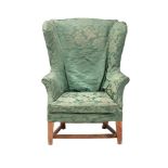 A GEORGE III ASH AND GREEN DAMASK UPHOLSTERED WING ARMCHAIR