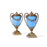 A PAIR OF GILT BRONZE AND OPALINE GLASS CANDLE VASES IN THE MANNER OF MATTHEW BOULTON