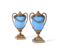 A PAIR OF GILT BRONZE AND OPALINE GLASS CANDLE VASES IN THE MANNER OF MATTHEW BOULTON