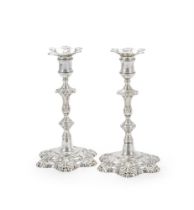 A PAIR OF GEORGE II CAST SILVER CANDLESTICKS