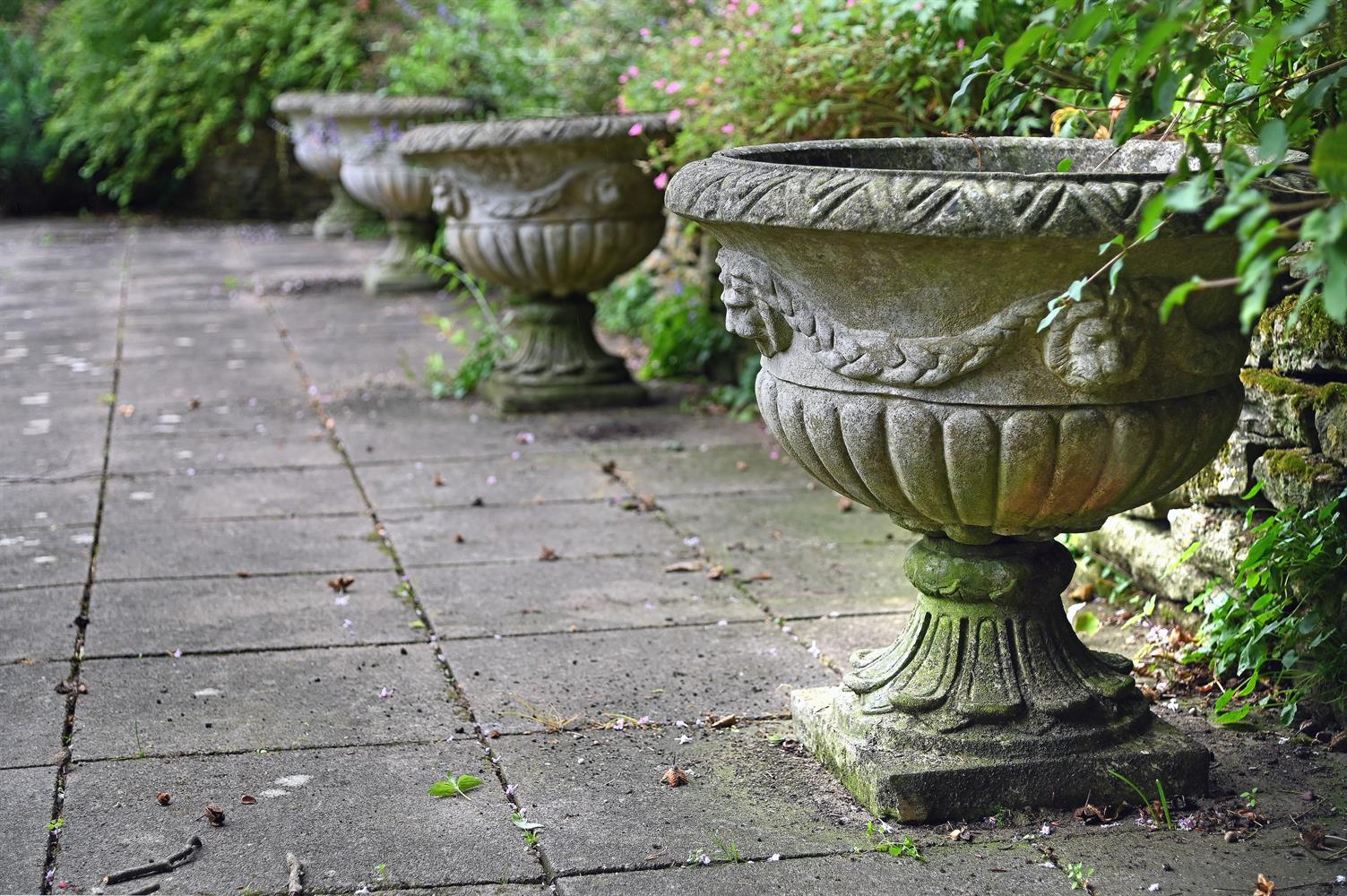 A SET OF FOUR STONE COMPOSITION URNS, IN 19TH CENTURY STYLE, 20TH CENTURY