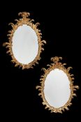 A PAIR OF CARVED GILTWOOD OVAL WALL MIRRORS, IN 18TH CENTURY STYLE, 20TH CENTURY