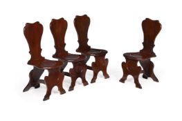 A SET OF FOUR GEORGE II SOLID MAHOGANY HALL CHAIRS, CIRCA 1750