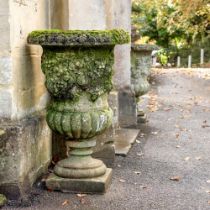 A PAIR OF STONE COMPOSITION 'FRUITING VINE' URNS, 20TH CENTURY