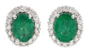 Pair of 18ct white gold oval emerald and round brilliant cut diamond stud earrings