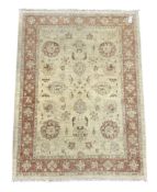 Beige ground rug with floral design and red border