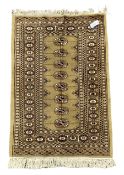 Small beige Bokhara rug with one central line of Gul motifs surrounded by border