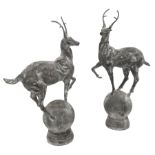 Pair of cast metal garden figures or gate post finials in the form of stags on spherical mounts