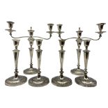 Set of four Edwardian silver candlesticks and pair of matching three light candelabra with tapering