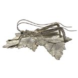 Modern silver model of a Grasshopper perched on leaves