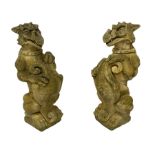Pair of composite stone garden ornaments in the form of griffins or gargoyles holding cartouche shie