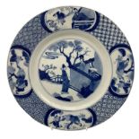 Chinese Kangxi plate decorated in blue and white with a figure looking over a wall with two figures