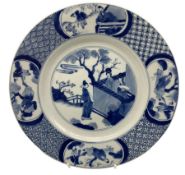 Chinese Kangxi plate decorated in blue and white with a figure looking over a wall with two figures