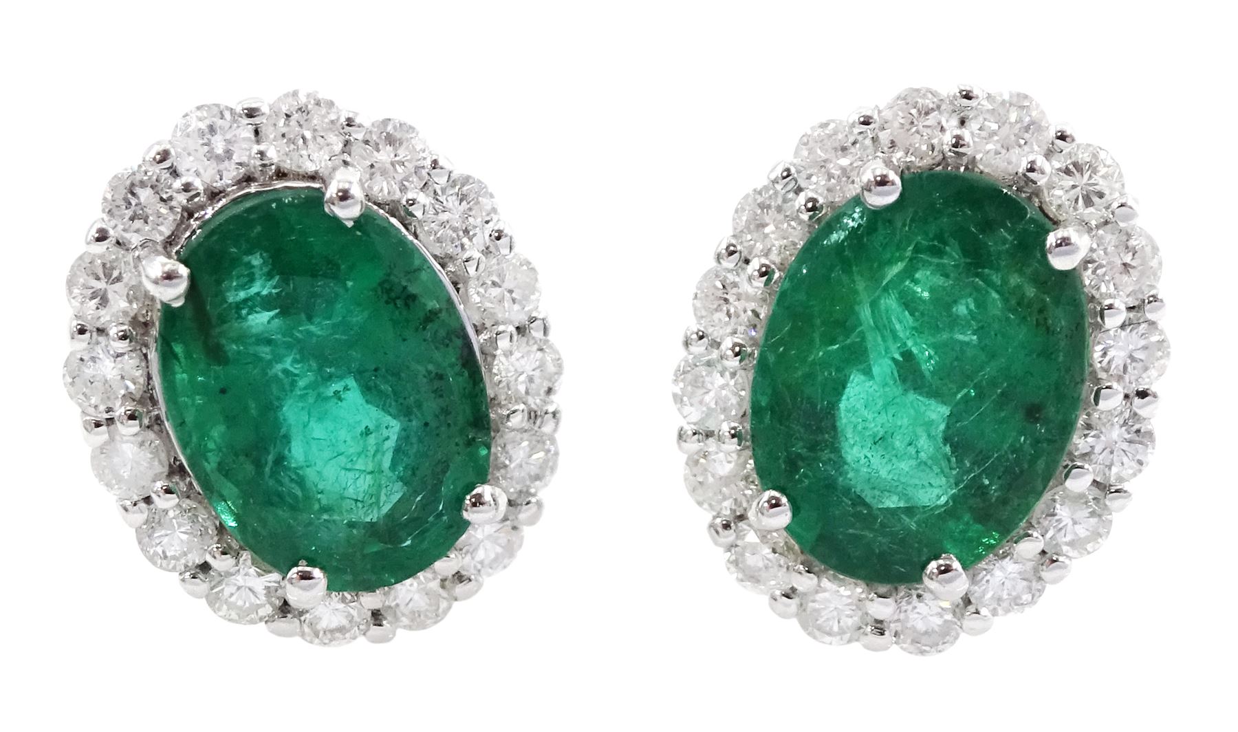 Pair of 18ct white gold oval emerald and round brilliant cut diamond cluster stud earrings