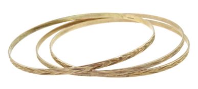 Three 9ct gold bangles with engraved decoration