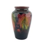 William Moorcroft baluster vase decorated with leaf and berry pattern on a shaded ground