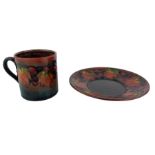 William Moorcroft coffee can and saucer decorated with leaf and berry pattern