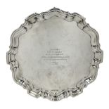 Silver circular salver with moulded edge and scroll feet with presentation inscription and a list of
