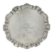 Silver circular salver with moulded edge and scroll feet with presentation inscription and a list of