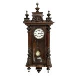 Late 19th century German 8-day striking wall clock in a mahogany case - pediment with carved decora