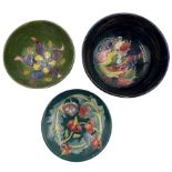 Three pieces of Moorcroft to include a William Moorcroft Leaf and Berries pattern bowl on blue groun