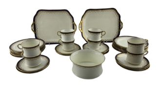 Cauldon tea set decorated with a blue and gilt border pattern comprising eight cups