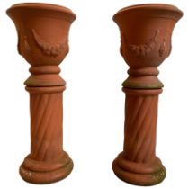 Pair of terracotta garden planters on pedestals